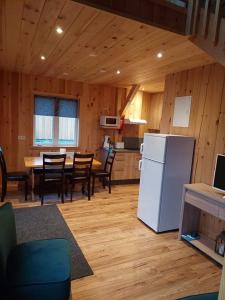 a kitchen with a white refrigerator and a table with chairs at Greystone summerhouse in Egilsstaðir