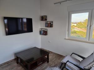 a living room with a tv and a coffee table at Aksa Residences in Vir