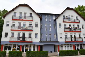 un gran edificio blanco con ventanas y balcones en Pilikán Apartments Lenti, en Lenti