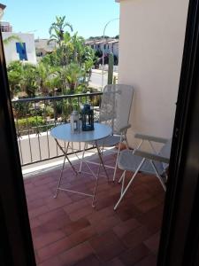 d'une table et de deux chaises sur un balcon. dans l'établissement IL VIAGGIO DI COSIMO, à San Vito Lo Capo