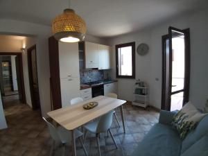 a kitchen and living room with a table and a couch at IL VIAGGIO DI COSIMO in San Vito lo Capo
