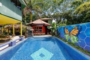 a swimming pool in front of a house with a butterfly mural at Casa Melosa in Potrero