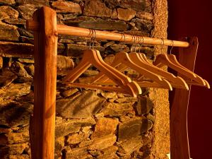 a bunch of wooden hangers hanging from a stone wall at Casa Gaveto in Sabugal +13 photos