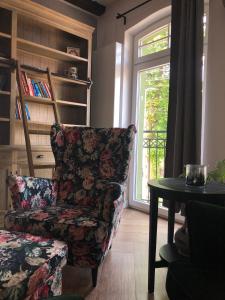 sala de estar con silla, mesa y ventana en Apartament Ernesta, en Krapkowice