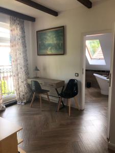 Habitación con mesa, 2 sillas y bañera. en Apartament Ernesta, en Krapkowice