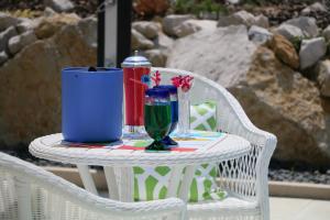 a white wicker chair with a table with a drink at Quinta da Chapeleira em Azeitão in Azeitao