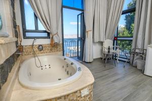 un ampio bagno con vasca con vista sull'oceano di Shirat Hayam Boutique Hotel a Tiberias