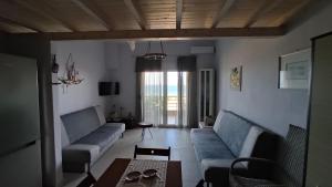 - un salon avec des canapés bleus et une table dans l'établissement Asterias Maisonette & Apartments, à Karianí