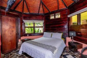 a bedroom with a bed in a room with wooden walls at Casa Melosa in Potrero