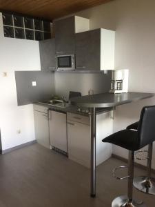 a kitchen with a counter with chairs and a microwave at Overpoint Panorama in Sasbachwalden