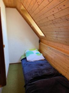 uma cama num pequeno quarto com tecto em madeira em Overpoint Panorama em Sasbachwalden