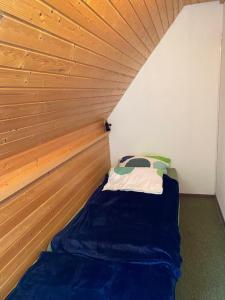 a small bed in a room with a wooden ceiling at Overpoint Panorama in Sasbachwalden