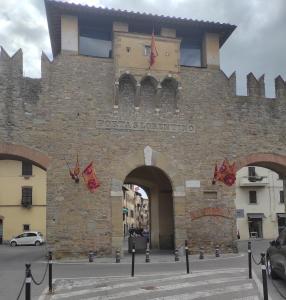 un grand bâtiment en pierre avec une arche dans une ville dans l'établissement La Casina, à Arezzo