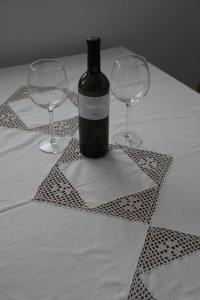 a bottle of wine sitting on a table with two wine glasses at Apartment MT Čezsoča in Bovec