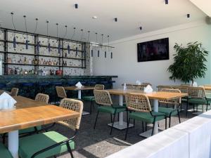 a dining room with wooden tables and green chairs at Mazoren Art Hotel in Faliraki