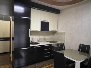 a kitchen with a table and a black refrigerator at Apartments Zevs 1 in Budva