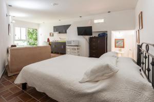 a bedroom with a large bed and a kitchen at Suite 5B, Cultura, Garden House, Welcome to San Angel in Mexico City