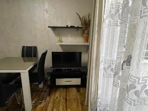 a room with a desk and a table with a television at Apartments Zevs 1 in Budva