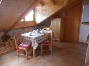 Un comedor con mesa y sillas en un ático. en Agritur Melango, en Fondo