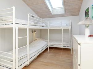 セビーにあるHoliday home Sæby IIIの白い二段ベッドと窓が備わる客室です。