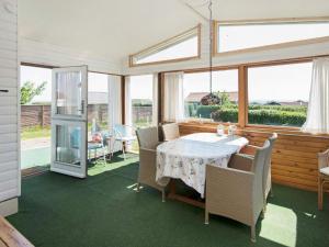a dining room with a table and chairs and windows at Panoramic Cottage Retreat-By Traum in Hejls