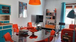 uma sala de estar com uma mesa de vidro e cadeiras laranja em La Encomienda de Almagro II em Almagro