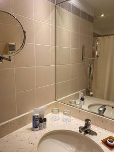 a bathroom with a shower, sink, and mirror at Del Pilar Miraflores Hotel in Lima
