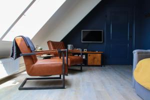 ein Wohnzimmer mit einem Stuhl und einem TV in der Unterkunft B&B Schotererf in Kuinre