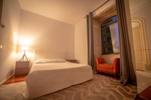 a bedroom with a bed and an orange chair at Quinta da Malaposta - Boutique Hotel & Eventos in Vila Nova de Cerveira