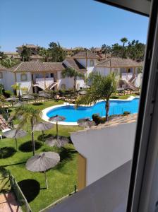 a view of the pool at a resort with umbrellas at Playa Golf IV in Islantilla