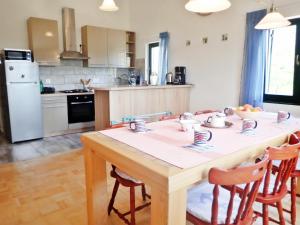 a kitchen with a wooden table with chairs and a table and a table at Apartment in Starigrad-Paklenica 38616 in Starigrad