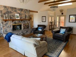 a living room with a couch and a stone fireplace at Villa Alta Vista at Yosemite- Stunning Views and Game Room in Mariposa