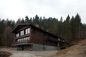 duży drewniany budynek w środku lasu w obiekcie Karolinka Guest House w Szczyrku