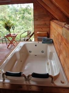 a large bath tub in a cabin with a patio at Cabaña Arrayanes in Rionegro