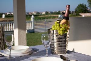 una mesa con una cesta de uvas y una botella de vino en IL-Holidays Paralia en Paralia Katerinis