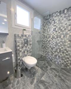 a bathroom with a toilet and a glass shower at IL-Holidays Paralia in Paralia Katerinis
