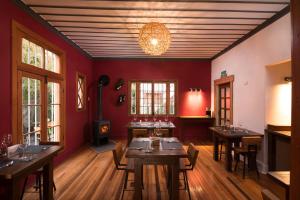 una sala da pranzo con pareti rosse e tavoli in legno di Esencia Hotel Boutique a Viña del Mar