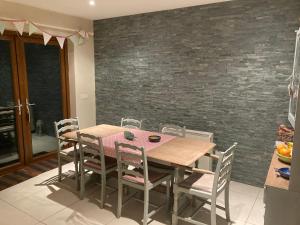 a dining room with a wooden table and chairs at Beautiful Central 3-Bed House in Co Clare in Milltown Malbay