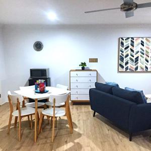 ein Wohnzimmer mit einem Sofa, einem Tisch und Stühlen in der Unterkunft Large Studio Unit Close to Theme Parks in Gold Coast