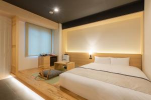 - une chambre avec un grand lit blanc et une fenêtre dans l'établissement Tosei Hotel Cocone Asakusa Kuramae, à Tokyo