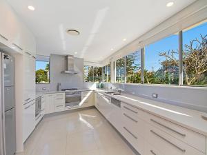 
a kitchen with a white counter top and a large window at Neilson on the Park Unit 1A - Easy walk to beaches, cafes and shopping in Coolangatta in Coolangatta
