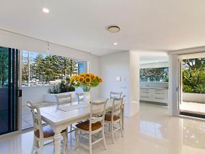 
a kitchen with a table and chairs and a large window at Neilson on the Park Unit 1A - Easy walk to beaches, cafes and shopping in Coolangatta in Coolangatta
