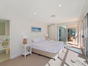 
a hotel room with a bed, chair and a window at Neilson on the Park Unit 1A - Easy walk to beaches, cafes and shopping in Coolangatta in Coolangatta
