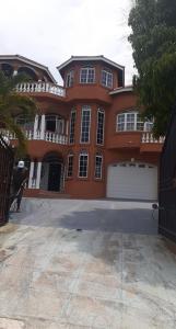 a large orange house with a white garage at Cazwin Villas in Montego Bay