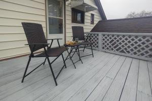 two chairs and a table on a deck at Historic w/deck, king bed & air by Lake Michigan in Manistee