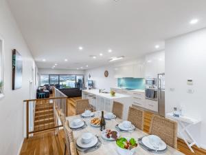 a kitchen and living room with a table and chairs at Casa al Mare the jewel of Fingal Bay with stunning views WiFi and Air Conditioning in Fingal Bay