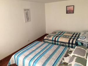 a bedroom with two beds and a picture on the wall at Estadía El Dorado in Bogotá +18 photos
