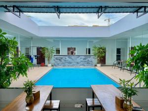 an indoor swimming pool with tables and plants at Onederz Sihanoukville in Sihanoukville