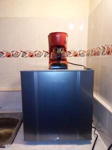 a red coffee maker sitting on top of a counter at Mirador Valle del Tomine - Cabaña vista al embalse in Guatavita +19 photos