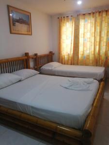 two twin beds in a bedroom with curtains at Hotel Cartagena Airport in Cartagena de Indias